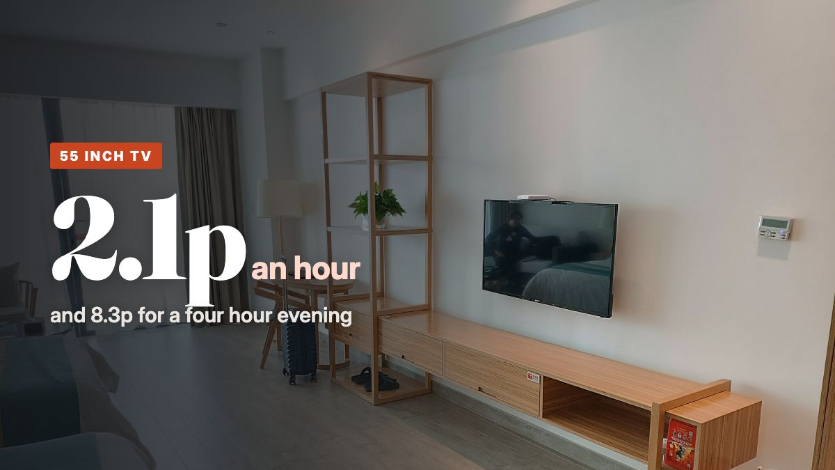 A flat screen TV mounted on the wall above a long wooden TV unit in a modern living room
